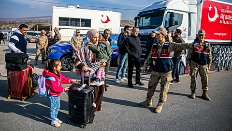 Syrian families arrive at the Selvigozu border gate to cross into Syria from Turkey near Antakya, southern Turkey, on Tuesday, 10 December 2024