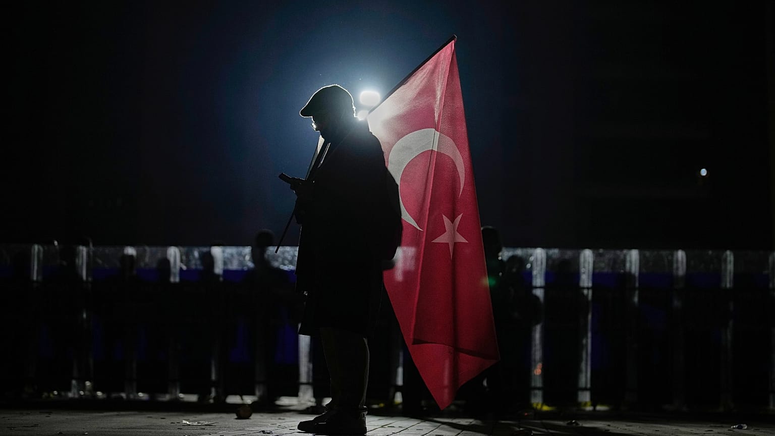İmamoğlu'nun tutuklanmasına karşı düzenlenen protesto sırasında çevik kuvvet polisi nöbet tutarken bir protestocu, 23 Mart günü Çağlayan Adliyesi dışında görüntüleniyor.