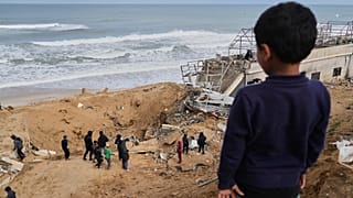 Palestinianos inspeccionam os escombros de uma estrutura atingida por um bombardeamento israelita em Deir al-Balah, na Faixa de Gaza, no sábado, 22 de março de 2025. (AP Photo/Abdel Kareem Hana)
