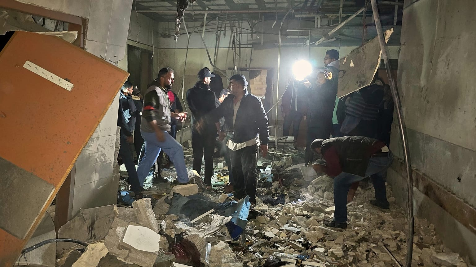 Trabalhadores de resgate inspecionam um quarto no hospital Nasser depois de ter sido atingido por um ataque do exército israelita em Khan Younis, 23 de março de 2025.