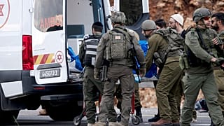 جنود إسرائيليون ينقلون جثة مسلح فلسطيني مشتبه به إلى سيارة إسعاف بعد هجوم إطلاق نار استهدف حافلة إسرائيلية الضفة الغربية، الجمعة، 29 نوفمبر/تشرين الثاني 2024.