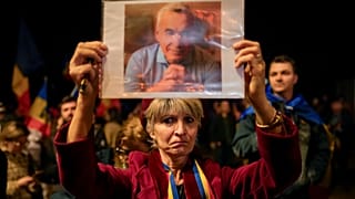 Tüntető Calin Georgescu arcképével