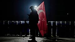 Ein Demonstrant hält eine türkische Flagge, während Bereitschaftspolizisten während einer Demonstration gegen die Verhaftung des Istanbuler Bürgermeisters Ekrem Imamoglu vor dem Caglayan-Gericht in Istanbul Wache stehen,