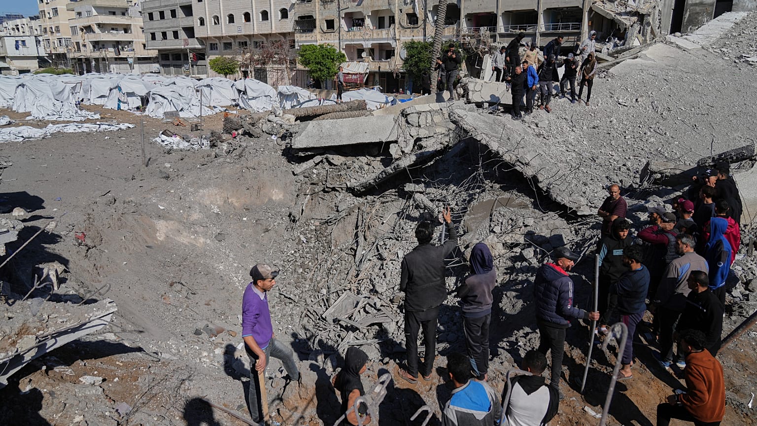 Palestinians inspect the site hit by an Israeli bombardment in Gaza City, 23 March, 2025