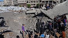 Palestinians inspect the site hit by an Israeli bombardment in Gaza City, 23 March, 2025