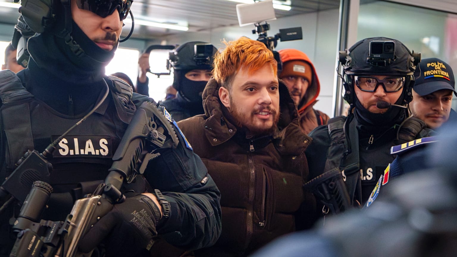 Mohamed Amra, nicknamed ''The Fly", is escorted by armed police officers at the Henri Coanda international airport in Otopeni, Romania, 25 February 2025.