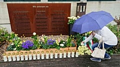 Eine Frau legt während einer Gedenkfeier auf dem Schulhof des Joseph-Koenig-Gymnasiums in Haltern, Deutschland, eine Rose nieder.