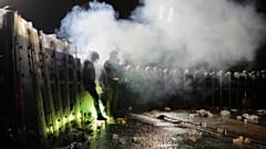 Von Demonstranten geworfene Feuerwerkskörper explodieren neben Bereitschaftspolizisten während einer Demonstration nach der Verhaftung und Inhaftierung des Istanbuler Bürgermeisters Ekrem Imamoglu in Istanbul, Türkei, am Sonntag,