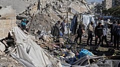 Palestinos inspeccionan el lugar alcanzado por un bombardeo israelí, en la ciudad de Gaza, el domingo 23 de marzo de 2025.