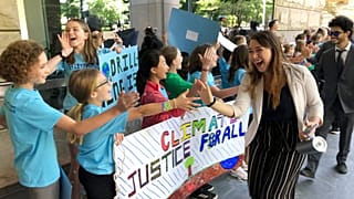 Kelsey Juliana, of Eugene, Ore., greets climate supporters outside a federal courthouse, June 4, 2019, in Portland, Ore.
