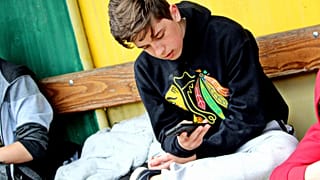 Un adolescente maneja un dispositivo móvil.