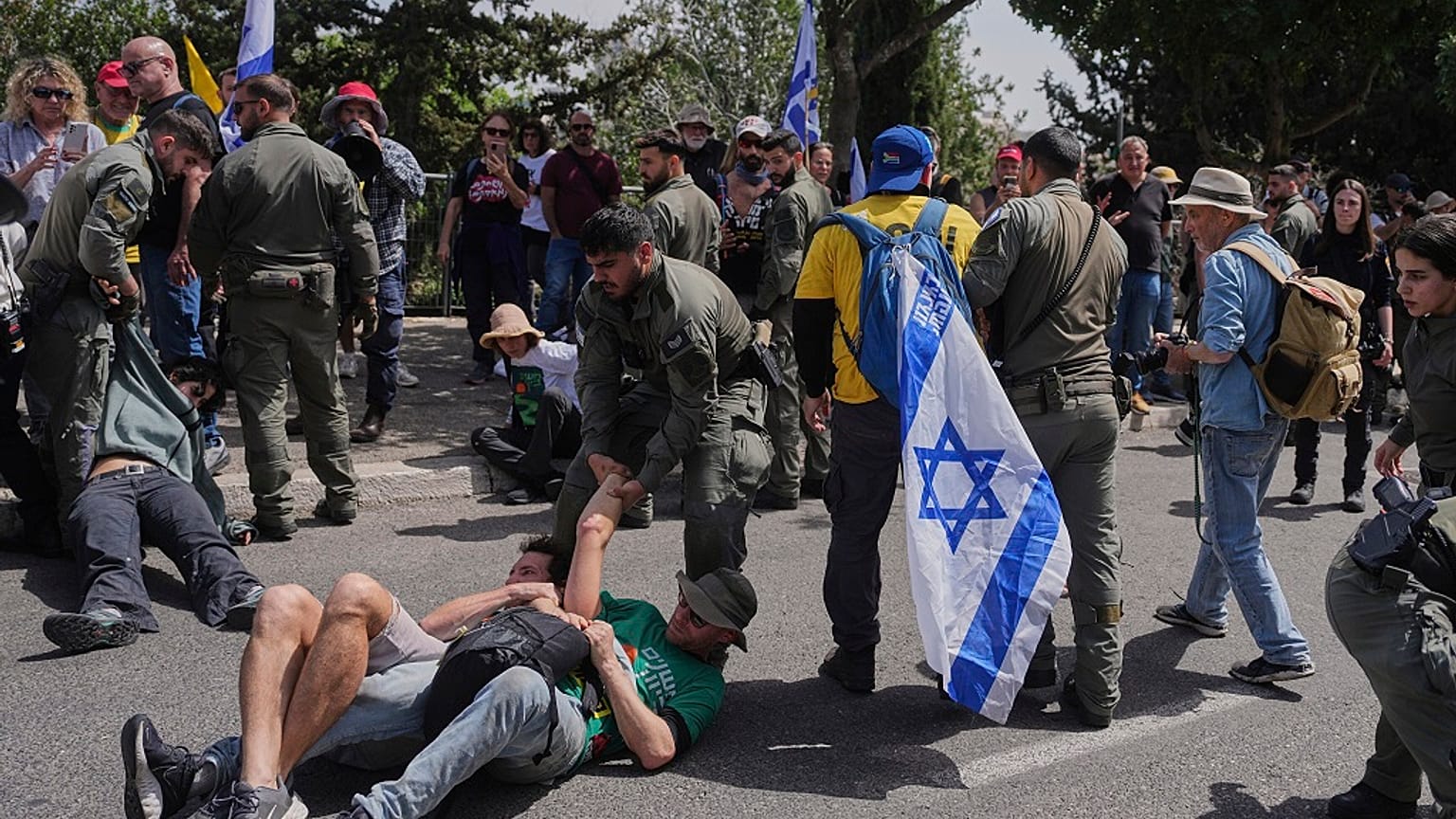 Des policiers israéliens dispersent des manifestants qui bloquent la route menant au parlement avant un vote clé sur le budget de l'État à Jérusalem, mardi 25 mars 2025.