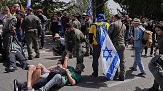 Des policiers israéliens dispersent des manifestants qui bloquent la route menant au parlement avant un vote clé sur le budget de l'État à Jérusalem, mardi 25 mars 2025.