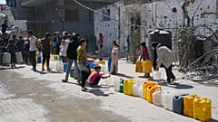 Des Palestiniens font la queue pour remplir des bidons d'eau à Jabaliya, dans le nord de la bande de Gaza, dimanche 16 mars 2025.