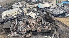 Eine Person geht an Häusern vorbei, die durch Waldbrände in einem Dorf in Yeongyang, Südkorea, zerstört wurden, Mittwoch, 26. März 2025.