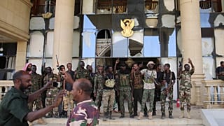 Sudan's army soldiers celebrate after they took the Republican Palace in Khartoum