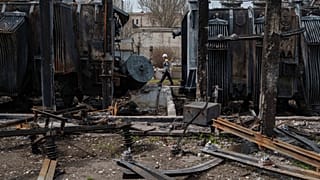Un lavoratore della società DTEK davanti ai trasformatori di una sottostazione distrutta da un attacco di droni russi in una località sconosciuta, Ucraina, 25 marzo 2025