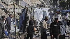 Palestinians inspect the site hit by an Israeli bombardment, in Gaza City