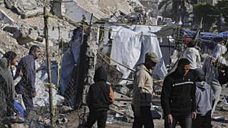 Palestinians inspect the site hit by an Israeli bombardment, in Gaza City