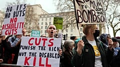 Protesters in London show placards as Britain's Chancellor Rachel Reeves prepares to deliver her spring statement to the House of Commons.
