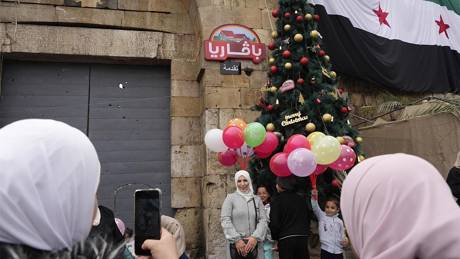 Syryjska muzułmanka pozuje do zdjęcia przed choinką w dzielnicy Bab Touma,