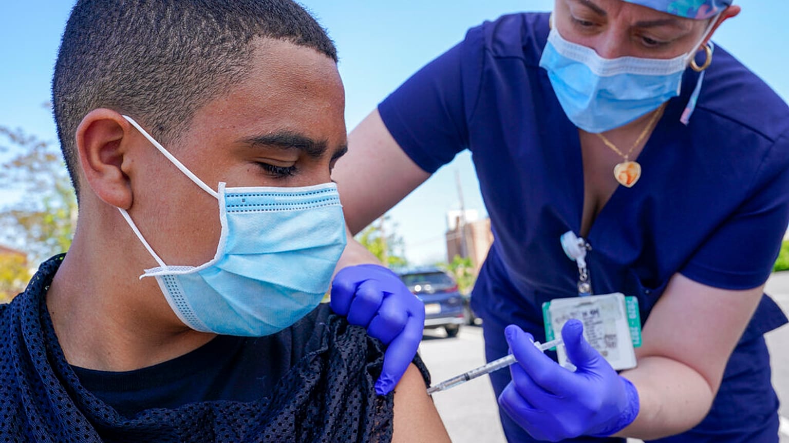 Justin Bishop, 13 anos, observa enquanto a enfermeira Jennifer Reyes o inocula com a primeira dose da vacina Pfizer COVID-19 no Mount Sinai South Nassau Vaxmobile, em 2021