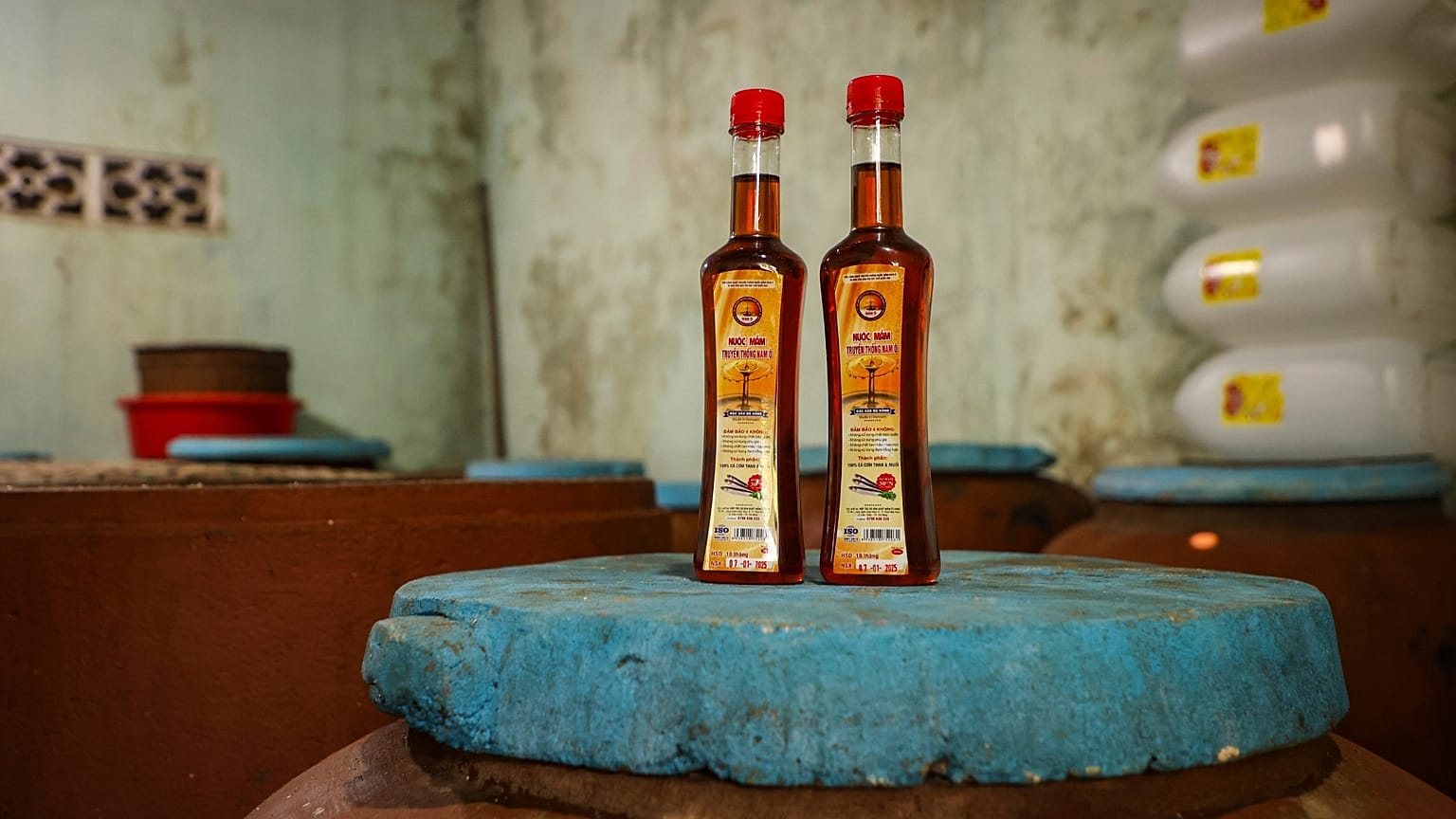 Botellas de salsa de pescado sobre ollas de fermentación en casa de Phan Cong Quang.