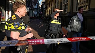 Funkcjonariusze policji stoją za odgrodzonym obszarem po pchnięciu nożem w pobliżu placu Dam w centrum Amsterdamu.