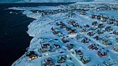 Mit Schnee bedeckte Häuser an der Küste einer Meeresbucht in Nuuk, Grönland, Freitag, 7. März 2025