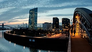 Un grupo de personas camina por un puente sobre el río Meno cerca del Banco Central Europeo en Fráncfort, Alemania, el 25 de marzo de 2025.