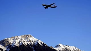 Ein Flugzeug der British Airways fliegt im Anflug auf den Flughafen Innsbruck tief über die Alpen.