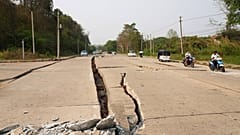 Des véhicules se frayent un chemin près d'une route endommagée par un tremblement de terre, vendredi 28 mars 2025, à Naypyitaw, au Myanmar.