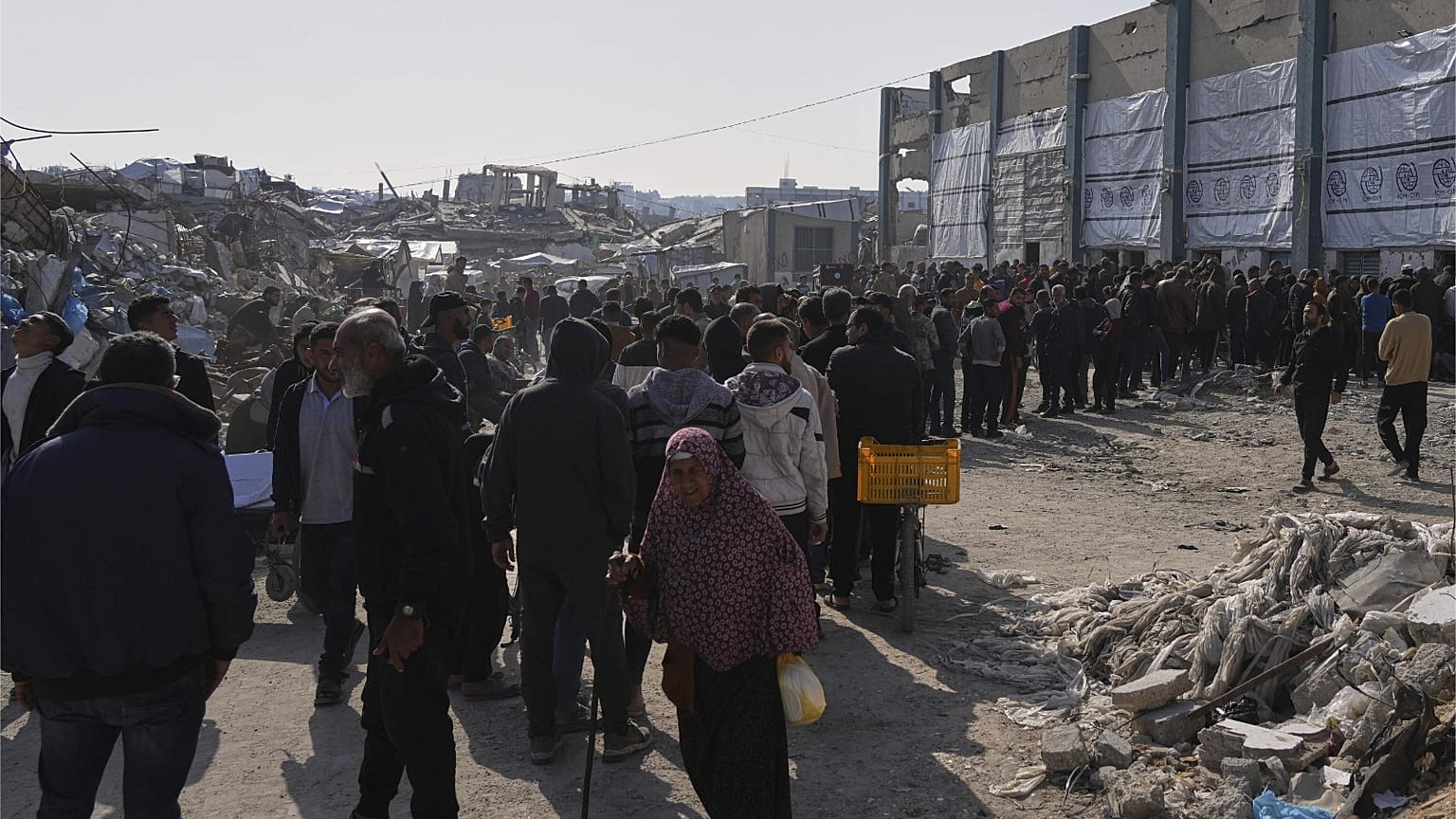 فلسطينيون ينتظرون في طابور لتلقي أكياس الطحين والمساعدات الإنسانية الأخرى التي وزعتها الأونروا ، وهي وكالة الأمم المتحدة لمساعدة اللاجئين الفلسطينيين في جباليا ، قطاع غزة