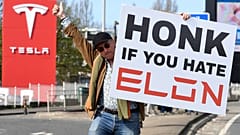 Protestujący trzyma transparent, biorąc udział w Akcji Tesla Takedown w pobliżu salonu Tesli w Londynie, 29 marca 2025 r.