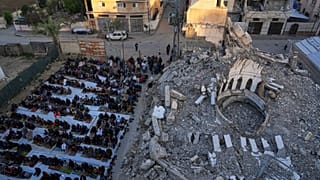 فلسطينيون يشاركون في صلاة عيد الفطر في دير البلح في قطاع غزة، الأحد، 30 مارس/آذار 2025