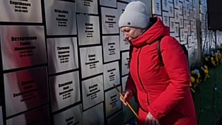 Eine Frau nimmt an einer Gedenkfeier für getötete Zivilisten teil, um den dritten Jahrestag der russischen Invasion in der Ukraine in Bucha, Ukraine, am 24. Februar 2025 zu markieren.