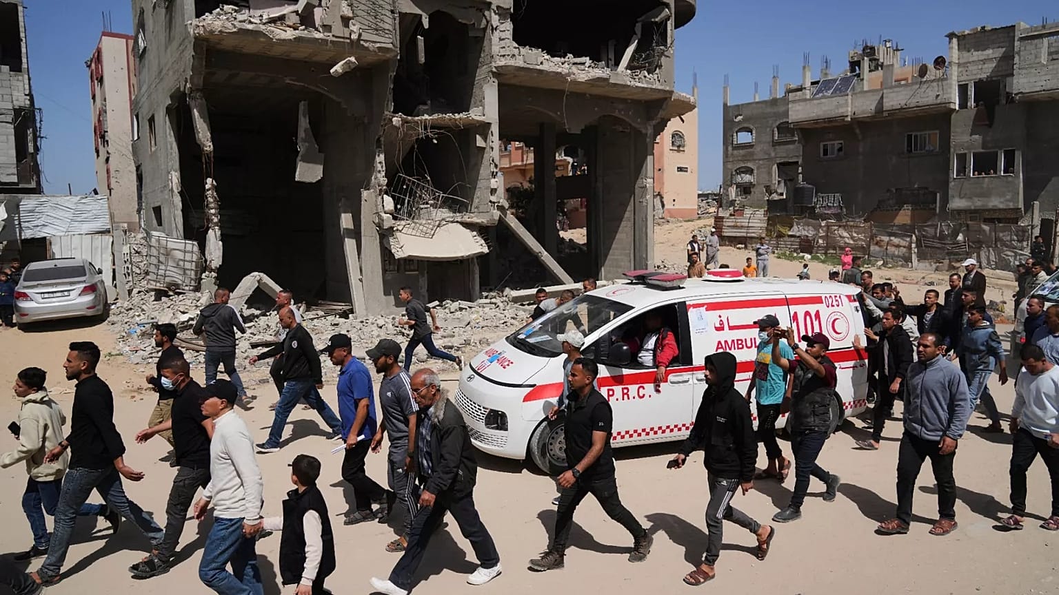 Trauernde folgen dem Konvoi mit den Leichen von 8 Rettungskräften des Roten Halbmonds, die in Rafah geborgen wurden, während sie zur Beerdigung in Deir al-Balah transportiert werden, 31. März 2025