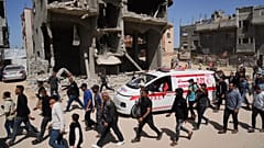 Trauernde folgen dem Konvoi mit den Leichen von 8 Rettungskräften des Roten Halbmonds, die in Rafah geborgen wurden, während sie zur Beerdigung in Deir al-Balah transportiert werden, 31. März 2025