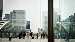 Menschen spazieren im Geschäftsviertel La Defense außerhalb von Paris. 21. März 2025.