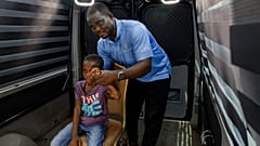 Rita Zaansuma-Naporo, de 9 años, acompañada por su padre, asiste a una prueba en directo de la tecnología de telemedicina en 3D en el hospital de Koforidua, Ghana.
