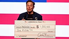 Ο Elon Musk κρατάει μια επιταγή ύψους 1 εκατομμυρίου δολαρίων σε ένα δημαρχείο στις 30 Μαρτίου 2025, στο Green Bay του Ουισκόνσιν. 