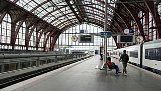 امرأة تجلس على مقعد في قاعة مغادرة شبه فارغة بمحطة القطار المركزية خلال إضراب عام في أنتويرب ، بلجيكا ، الاثنين 31 مارس 2025. 