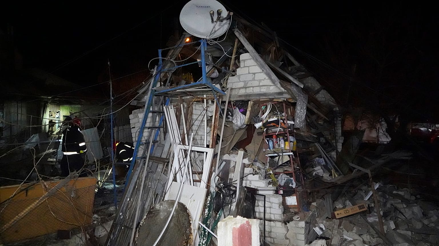 Trabalhadores de resgate limpam os escombros de uma casa destruída num ataque russo a um bairro residencial de Kharkiv, Ucrânia, sábado, 29 de março de 2025. 