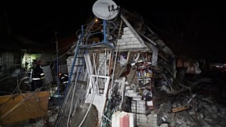 Trabalhadores de resgate limpam os escombros de uma casa destruída num ataque russo a um bairro residencial de Kharkiv, Ucrânia, sábado, 29 de março de 2025.
