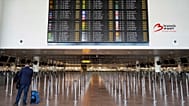 Um homem com bagagem em frente a um painel de partidas cheio de cancelamentos, durante uma greve geral, no Aeroporto Internacional de Bruxelas.