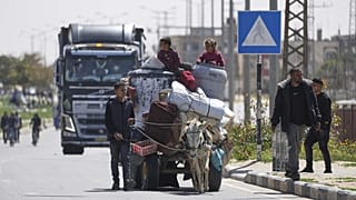 A Gázai övezet déli részén lévő Rafahból elmenekült emberek érkeznek az övezet középső részén lévő Hán-Júniszba 2025. március 31-én