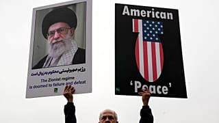 متظاهر إيراني يحمل لافتة مناهضة للولايات المتحدة وملصق للمرشد الأعلى آية الله علي خامنئي مع اقتباس منه ضد إسرائيل خلال يوم القدس السنوي المناهض لإسرائيل ، أو مسيرة يوم القدس ل