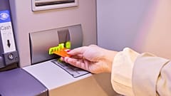Eine Person, die Geld von einem Geldautomaten abhebt