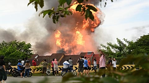 Des habitants regardent un immense incendie se déclencher à la suite d'une fuite de gaz à Putra Heights, dans l'État central de Selangor, en Malaisie, le mardi 1er avril 2025.
