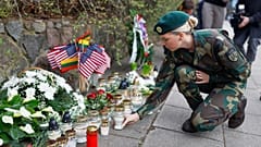 Ein Soldat der litauischen Armee zündet eine Kerze zum Gedenken an drei Soldaten an, die am Montag auf einem Übungsplatz in Pabradė tot aufgefunden wurden, 1. April 2025